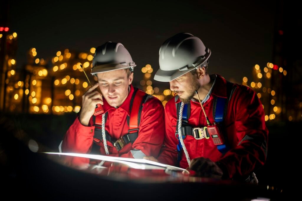 Engineer survey team wear uniform and helmet stand workplace checking blueprint project and radio co